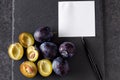 Plums, whole and slices with blank paper - add own text Royalty Free Stock Photo