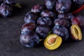 Plums, whole and slices on dark background Royalty Free Stock Photo