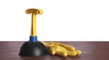 Plunger with plastic handle and rubber gloves on wooden table