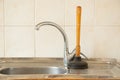 The plunger stands at the sink in the kitchen, cleaning clogged pipes, plunger for cleaning pipes Royalty Free Stock Photo
