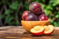 Pluot, mix of plum and apricot in wooden bowl Royalty Free Stock Photo