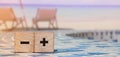 Plus and minus sign on wooden cubes on relaxed beach . Business online concept