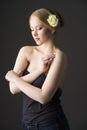 Plus size blonde with a yellow rose in her hair posing on a gray seamless background Royalty Free Stock Photo