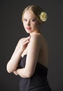 Plus size blonde with a yellow rose in her hair posing on a gray seamless background Royalty Free Stock Photo