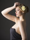 Plus size blonde with a yellow rose in her hair posing on a gray seamless background Royalty Free Stock Photo