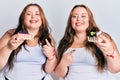Plus size caucasian sisters woman holding slice of cake smiling happy pointing with hand and finger