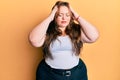 Plus size caucasian young woman wearing casual clothes with hand on head, headache because stress