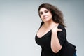 Plus size fashion model in black dress, fat woman on gray background, body positive concept Royalty Free Stock Photo