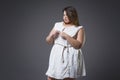 Plus size fashion model in casual clothes, fat woman on gray background, overweight female body Royalty Free Stock Photo