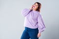 Plus size fashion model in casual clothes, fat woman on gray background