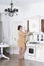 Plus size fashion model on kitchen, fat woman on luxury interior, overweight female body Royalty Free Stock Photo