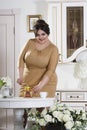 Plus size fashion model on kitchen, fat woman on luxury interior, overweight female body Royalty Free Stock Photo