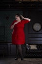 Plus size fashion model in red evening dress, fat woman on luxury interior Royalty Free Stock Photo