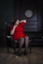 Plus size fashion model in red evening dress, fat woman on luxury interior Royalty Free Stock Photo