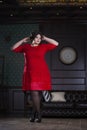 Plus size fashion model in red evening dress, fat woman on luxury interior, overweight female body, full length portrait Royalty Free Stock Photo
