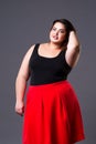 Plus size fashion model in red skirt, fat woman on gray background Royalty Free Stock Photo