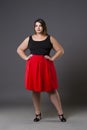 Plus size fashion model in red skirt, fat woman on gray background, overweight female body Royalty Free Stock Photo