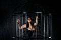 Plus size fashion model in sexy clothes in a steel cage, body positive concept