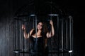 Plus size fashion model in sexy clothes in a steel cage, body positive concept Royalty Free Stock Photo