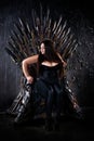 Plus size fashion model sitting on the iron throne Royalty Free Stock Photo