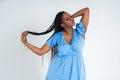 Plus size female model posing in blue dress on white background, young African woman with curvy figure and pigtailed hairstyle, Royalty Free Stock Photo