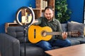 Plus size hispanic man with beard playing classic guitar at music studio recording himself with open hand doing stop sign with Royalty Free Stock Photo