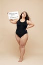 Plus Size Model. Fat Woman In Black Bodysuit Full-length Portrait. Female Holding Paper With Words.