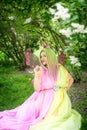 Plus size model in the form of a butterfly in a green blooming green garden. Fairy tale