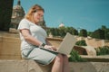 Plus size model girl working on laptop outdoors Royalty Free Stock Photo