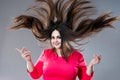 Plus size model with long hair blowing in the wind, brunette fat woman on gray background, body positive concept Royalty Free Stock Photo