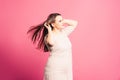 Plus size model with long hair blowing in the wind, fat woman on pink background Royalty Free Stock Photo