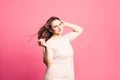 Plus size model with long hair blowing in the wind, fat woman on pink background Royalty Free Stock Photo