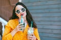 Plus size woman drinking take away cocktail over city cafe wall Royalty Free Stock Photo