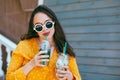 Plus size woman drinking take away cocktail over city cafe wall Royalty Free Stock Photo