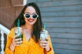 Plus size woman drinking take away cocktail over city cafe wall Royalty Free Stock Photo