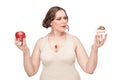 Plus size woman making choice between apple and pastry Royalty Free Stock Photo