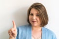 Plus-size woman making warning gesture with index finger, expressing caution and attention. Advice, attention, and Royalty Free Stock Photo