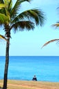 Plus size woman with short hair meditating and practicing yoga on a tropical beach.