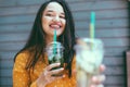 Plus size woman drinking take away cocktail over city cafe wall Royalty Free Stock Photo