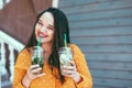 Plus size woman drinking take away cocktail over city cafe wall Royalty Free Stock Photo