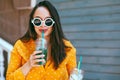 Plus size woman drinking take away cocktail over city cafe wall Royalty Free Stock Photo