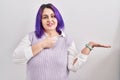 Plus size woman wit purple hair standing over white background showing palm hand and doing ok gesture with thumbs up, smiling Royalty Free Stock Photo