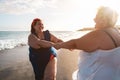 Plus size women dancing on the beach having fun during summer vacation - Curvy female laughing together - Overweight body and Royalty Free Stock Photo