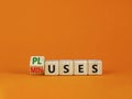 Pluses and minuses symbol. Turned a wooden cube and changed the word `minuses` to `pluses`. Beautiful orange table, orange Royalty Free Stock Photo