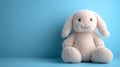 Plush bunny toy against a blue background. Royalty Free Stock Photo