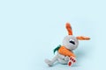 Plush grey easter bunny toy for little kids on pastel blue background. Copy space