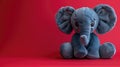 Plush grey elephant toy with big ears on a vibrant red background. Royalty Free Stock Photo