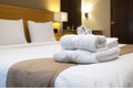 plush hotel bed with folded fresh towels Royalty Free Stock Photo