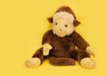 Plush monkey on a yellow background close up