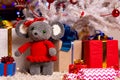 Plush mouse together with gifts under the Christmas tree